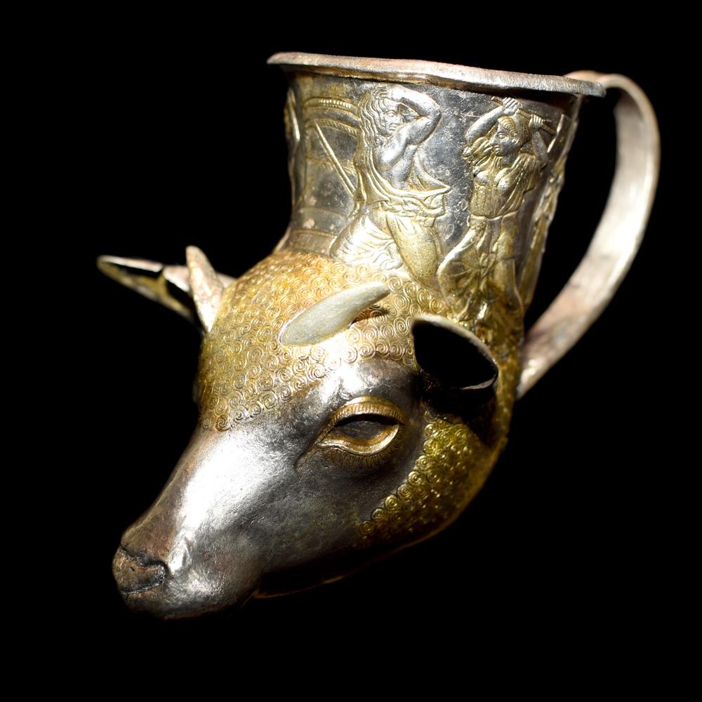 This unique rhyton - the head of a young ram - was found among the rich gifts in the grave of an Odrysian ruler. The upper part of the rhyton is decorated with a scene from Homer's Iliad – ‘The murder of the Trojan king Priam after the fall of Troy’. In classical Greece, killing Priam was considered a crime, but in Thrace the victor slaughtered the representatives of the defeated dynasty to eradicate it. The use of this Trojan scene in the Thracian funerary rite is probably intended to highlight the king as a victorious hero, destroyer of the old and founder of the new dynasty.